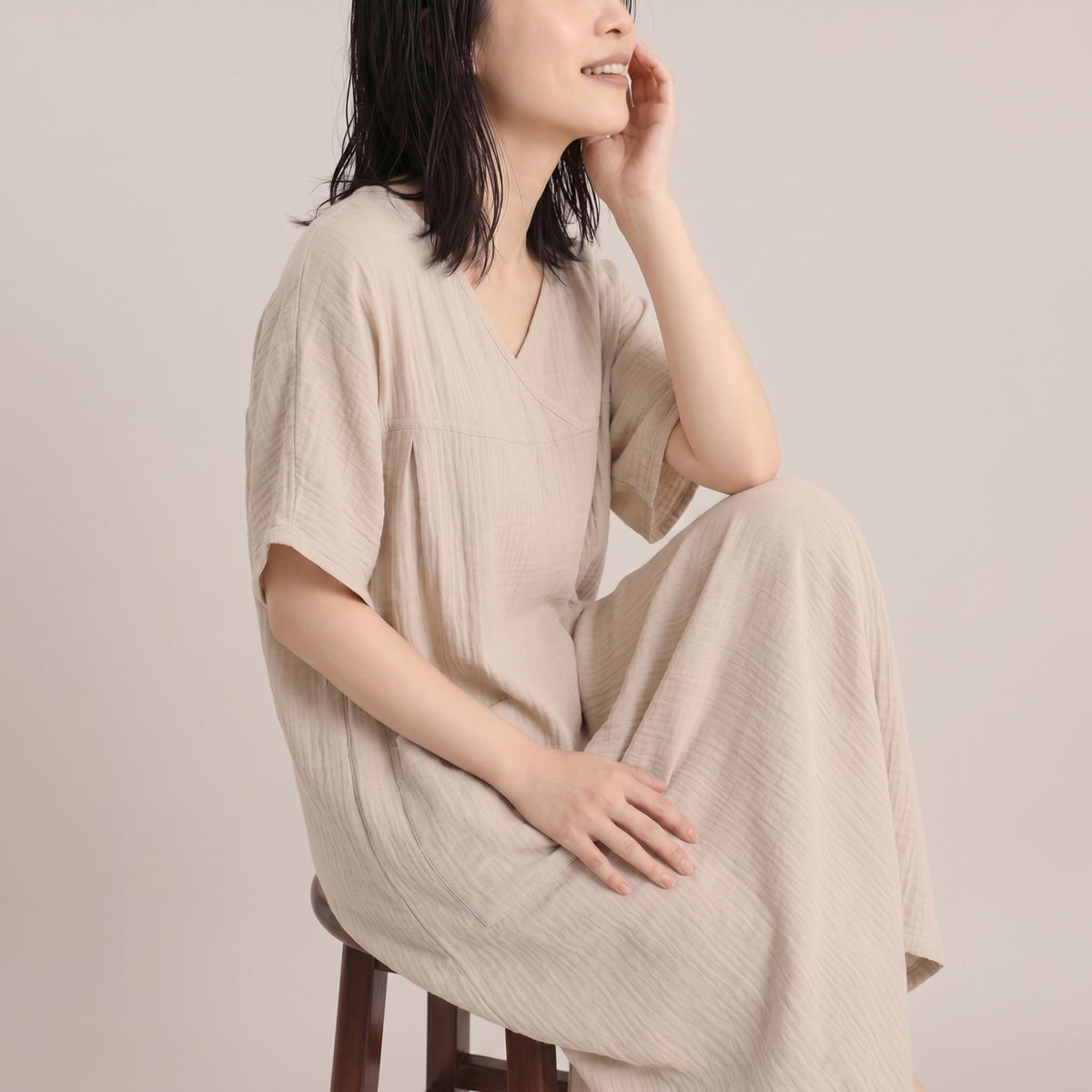 Woman with damp hair relaxing in the beige post-shower cotton gauze dress