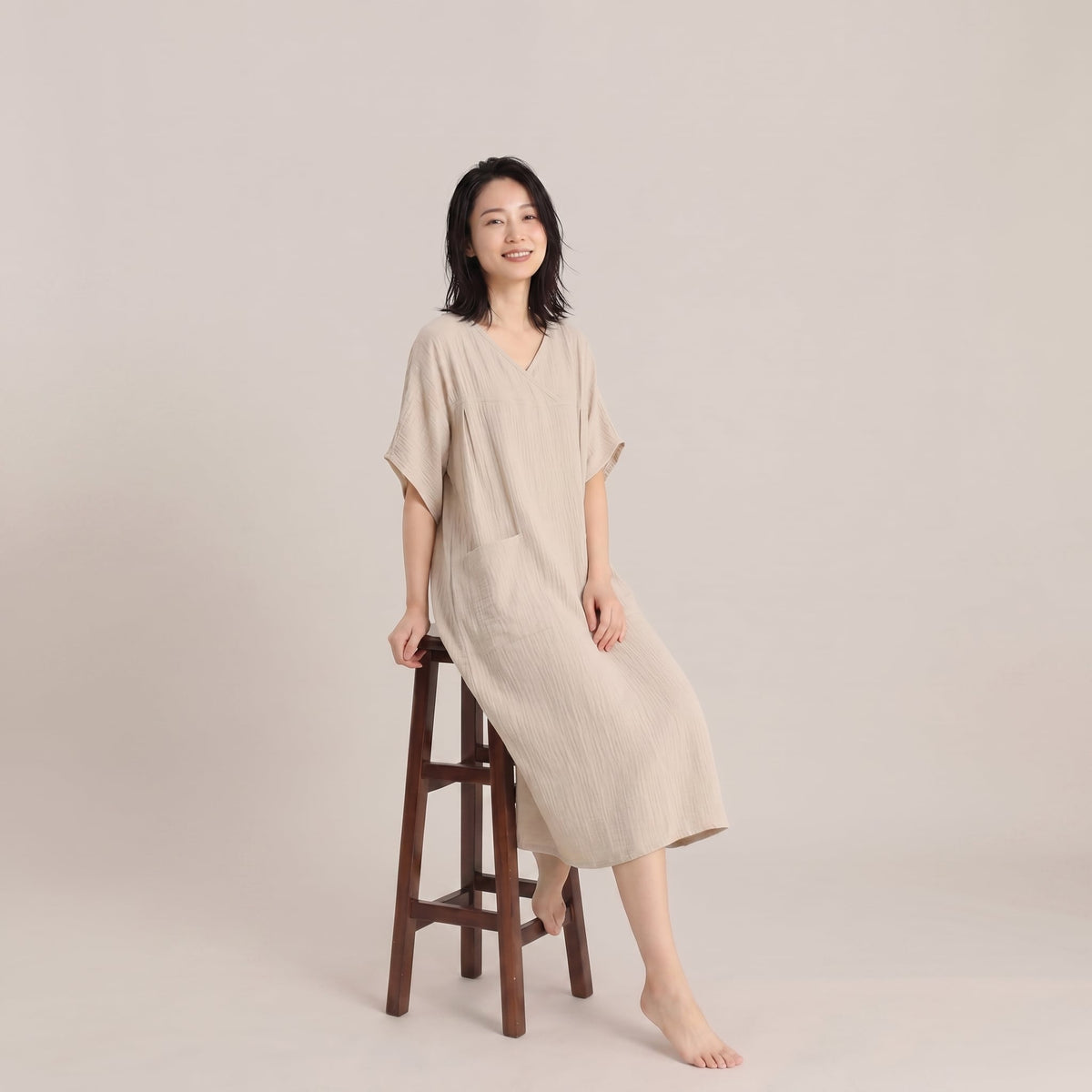 Relaxed fit of the beige post-shower lounge dress while seated